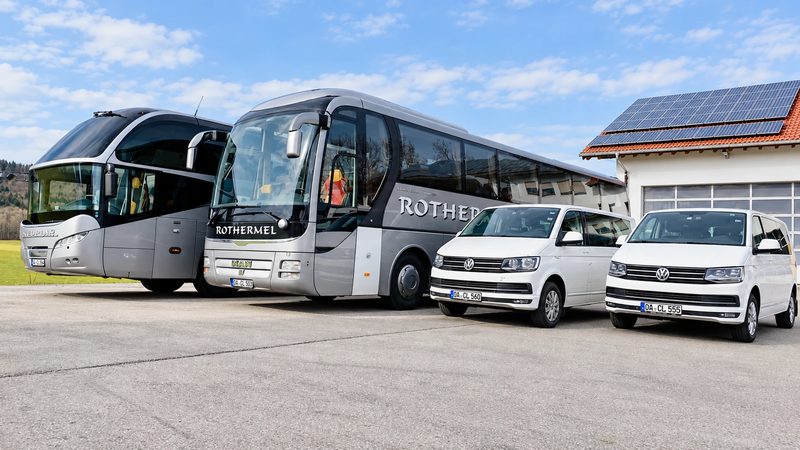 Zwei Reisebusse und zwei VW-Busse von Rothermel Reisen vor dem Betriebshof in Wildpoldsried